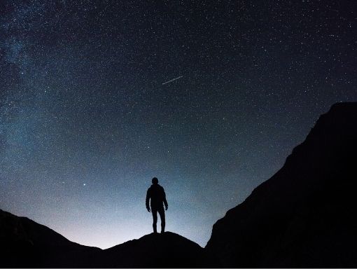 Silhouette of Man standing on mountain at night